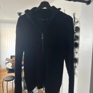 Svart full zip från J.Lindeberg - Säljer en stilren heavy weight cotton Full zip från J.Lindeberg. Den har en dragkedja framtill och är perfekt för både avslappnade och mer uppklädda tillfällen. Passar bra till vår, höst och vinter. Storlek S passar även M. Helt ny med tags. Retail 2500kr säljer för endast 1200kr! 🔥