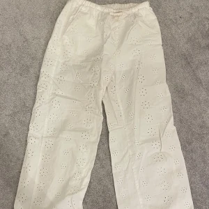 Linnebyxor med broderade detaljer  - Säljer ett par vita linnebyxor från H&M med broderade blommönster. Det är dubbelt tyg upptyg så inte alls genomskinliga. Fint skick, endast lite små märken vid foten. Använt fåtal gånger. 💘 Passar för 160cm! Storlek 158 men passar även xs.