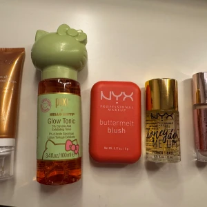 Sminkprodukter  - Säljer en samling sminkprodukter inklusive Pixi Glow Tonic med Hello Kitty-design och NYX Buttermelt Blush. Inkluderar även NYX Honey Dew Me Up Primer. Hickap bronze drops och revolution concealer i c2