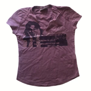 Lila t-shirt från Funky Girl - Säljer en lila t-shirt från Funky Girl med tryck av en person på framsidan.(Den är inte stretchy så det passar size xs och mindre bäst.)
