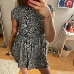 Blommig kortklänning - Söt blommig kortklänning med rund hals och korta ärmar från Tommy Hilfiger. Perfekt för sommarens skolavslutning. Strl 14