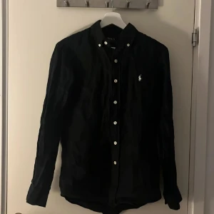 Svart skjorta från Polo Ralph Lauren - Säljer denna svarta snygga linne skjorta från polo Ralph lauren pga att jag inte använt den. Ny pris 1600 jag säljer den för 550kr. Priset är inte satt i sten. Skriv vid minsta fundering.
