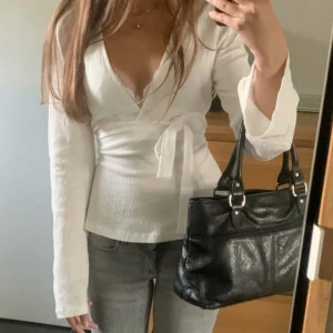 Vit omlottopp - Säljer en stilren vit omlottopp med långa ärmar och knytband i midjan. Knappt använd 💓💓