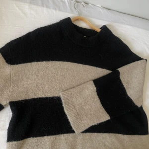 Svart och beige tröja från Gina Tricot - Säljer en mysig svart och beige tröja från Gina Tricot. Tröjan har ett randigt mönster och är perfekt för kyligare dagar. Den har långa ärmar och en bekväm passform.