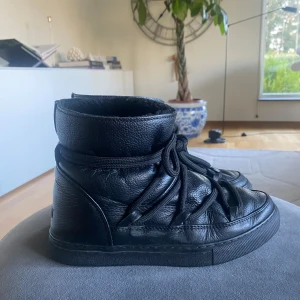 Svarta boots från Inuikii - Säljer ett par svarta boots från Inuikii i skinn med snörning. De har en robust sula och är fodrade för extra värme. Perfekta för kyligare dagar.