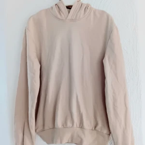 Beige hoodie - Säljer en stilren beige hoodie med långa ärmar och en klassisk huva. Perfekt för en avslappnad look. Passar bra till jeans eller mjukisbyxor.