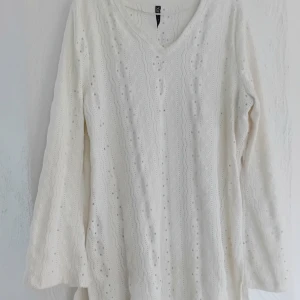 Vit stickad tröja med v-ringning - Säljer en vit stickad tröja med v-ringning och ett fint hålmönster. Tröjan har långa ärmar och en bekväm passform. Perfekt för varma dagar! Färgen syns bäst på andra bilden<3