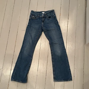 Blå bootcut jeans från Gina tricot 😛🫰🏻 - Snygga blå bootcut jeans med klassisk femficksdesign och knappgylf. Perfekta för en avslappnad stil med en touch av stockholmstil. Passar bra till sneakers eller boots. 🍒❣️