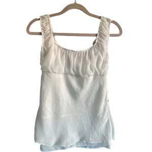 Vit topp - Supersnygg vit T-shirt med typ blusmaterial. Framsidan och baksidan är likadana därav bara en bild. Inga defekter och slitningar!💕Priset kan alltid diskuteras. Skriv om frågor finns!💕