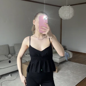 Svart topp med volanger - köpt 2022 i storlek S, använd få gånger 