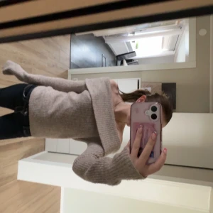 Beige ribbad offshoulder tröja från H&M - Säljer en stilren beige ribbad offshoulder tröja från H&M. Tröjan har långa ärmar och en mjuk, bekväm passform. Passar utmärkt till både jeans och kjol. I storlek S
