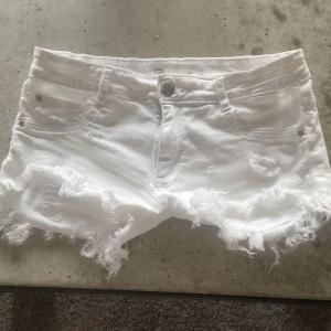 Vita jeansshorts med fransar - Säljer ett par vita jeansshorts med fransiga kanter.  Perfekta för sommardagar! 🌞fråga om ni undrar något💕