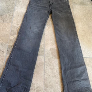 Grå jeansbyxor från 157 - Snygga grå jeansbyxor från 157 med en klassisk femficksdesign. Byxorna har en rak passform och är perfekta för en avslappnad stil. De har en knappgylf och bälteshällor för extra funktionalitet.