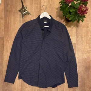 Mörkblå Skjorta från Zara Man Slim Fit - Snygg mörkblå skjorta från Zara Man med ett diskret prickigt mönster. Skjortan har långa ärmar och knappar framtill. Perfekt för en stilren look. Storlek XL men passar mer som Large. Snabb Leverans!