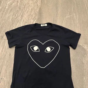 Cdg t-short - Mörk blå cdg t-shirt. Skick 7/10. Obs ett hål under högra armen hålet finns på bild 4 inget stort hål och inget som ses vid användning. Tröjan är själv fallet äkta