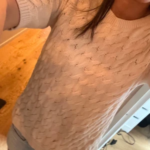Beige stickad tröja från Vero Moda - Säljer en snygg beige stickad tröja från Vero Moda med ett flätat mönster. Tröjan har korta ärmar och en rund halsringning. Perfekt för en stilren look. Hör av dig vid intresse! 😊