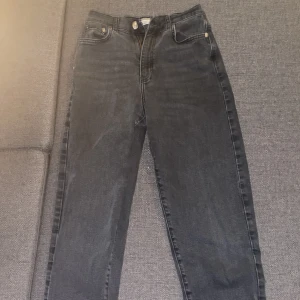 Svarta jeansbyxor från Gina Tricot - Snygga svarta jeansbyxor från Gina Tricot i en klassisk femficksmodell. Byxorna har en dragkedja och knapp framtill. Perfekta för en stilren look.