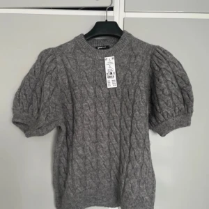 Grå stickad topp från Gina Tricot NWT Large - Stickad tröja med puffärm från Gina Tricot med kabelstickat mönster. NWT storlek Large