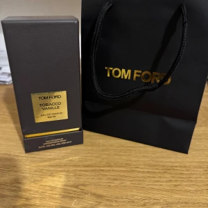 Tom Ford Tobacco Vanille 100ml EdP - Lyxig parfym från Tom Ford, Tobacco Vanille, 100 ml Eau de Parfum. Flaskan är svart med guldiga detaljer och har en elegant, fyrkantig form. Kommer i originalförpackning och med svart presentpåse med guldfärgad logga. Perfekt för dig som gillar exklusiva dofter.