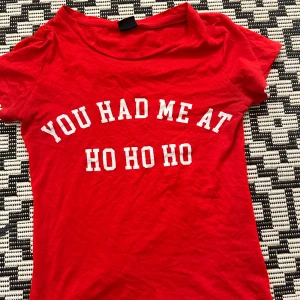 Röd jul-tshirt från Gina Tricot - Röd t-shirt från Gina Tricot med vit text 'YOU HAD ME AT HO HO HO' på bröstet. Klassisk rund halsringning och korta ärmar. Perfekt för dig som vill sprida julkänsla med stil. #meangirls #yk2