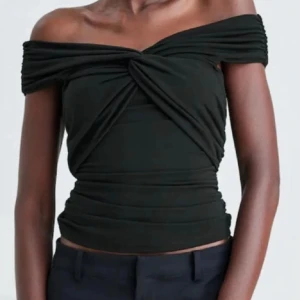 Svart offshoulder topp från Bik Bok - Säljer en svart offshoulder topp från Bik Bok med  twistad detalj framtill. 