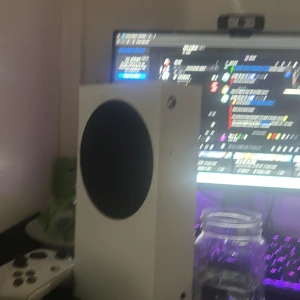 Xbox 120 fps  - Bilderna visar ett gaming-setup med Xbox Series S, handkontroll, tangentbord med RGB-belysning och en Logitech G-mus. Ingen bok syns på bilderna, så ingen beskrivning av bok kan ges.