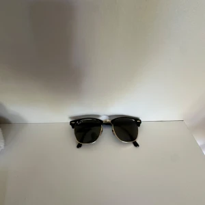 Ray-Ban Clubmaster  - Snygga Ray-Ban Clubmaster solglasögon med svart ovandel och guldfärgade detaljer. Klassisk halvbåge och gröntonade glas. Ikonisk modell som ger en tidlös vibe. Perfekt accessoar för att lyfta din stil. Glasögonen har inga repor eller defekter förutom att texten på högra bågen börjar blekna bort men är väldigt vanligt för denna modell. De här glasögonen är även nästan slutsålda  hos alla återförsäljare vilket gör de väldigt unika. Ifall ni vill göra ett kap så är det bara att skriva till mig 🙌👍
