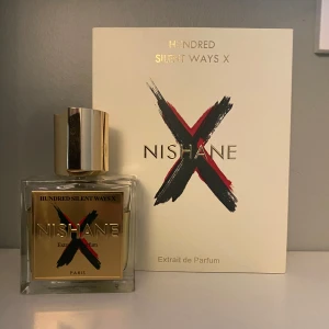 Nishane Hundred Silent Ways X Parfym - Exklusiv parfym från Nishane, Hundred Silent Ways X. Flaskan är fyrkantig i glas med en lyxig guldfärgad etikett och matchande guldlock. Doften har inslag av vit blomma, vanilj, läder, puder, animaliska toner, tuberos, frukt, sötma, rökighet och mjölkiga nyanser.