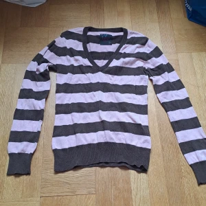 Randig v-ringad tröja - Snygg v-ringad tröja från Eve of Eden i brun och rosa med breda ränder. Långärmad och i mjukt, tunt stickat material. Färgen är mer rosa än på bilden. 🩷😊