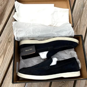 Blå mockaloafers från Massimo Dutti - Stilrena svarta loafers från Massimo Dutti i mjuk mocka med vit platt sula. Skorna har en klassisk slip-on design och diskreta sömdetaljer längs kanterna. Perfekta för dig som gillar en clean och tidlös look.