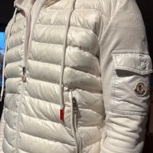 Vit Moncler Cardigan - Vit cardigan från Moncler! Jackan är i använt men fint skick. Jag har ej använt den mycket eftersom den är för liten. Få defekter finns. Tveka inte på att fråga om du undrar över något!