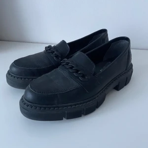 Svarta loafers från Rieker - Säljer ett par svarta loafers från Rieker, använda en gång.