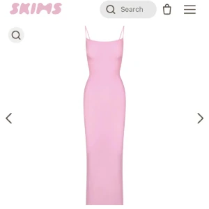 Ljusrosa långklänning från Skims - Supersnygg ljusrosa långklänning från Skims med smala axelband och figurnära passform. Perfekt för dig som vill ha en enkel men stilren look. Klänningen har en minimalistisk design och är riktigt bekväm.