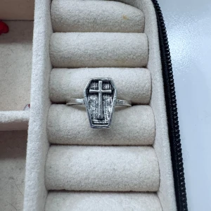 Ring med kistform och korsmotiv - Unik silverfärgad ring med en kistformad front och ett kors i mitten. Ringen har en rå, vintage-inspirerad look och passar dig som gillar alternativa eller gotiska smycken.