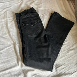 Svarta bootcut jeans - Säljer ett par svarta bootcut jeans med klassisk femficksdesign och knappgylf. Jeansen har en något utsvängd passform nertill och är perfekta för en avslappnad men ändå stilren look. Original pris 150kr.