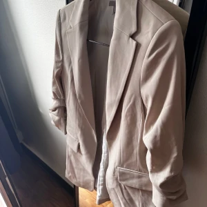 H&M beige kavaj, storlek XS - En väldigt snygg men även trendig kavaj från HM som har använts ett fåtal gånger, finns inga tydliga spår av användning på den 