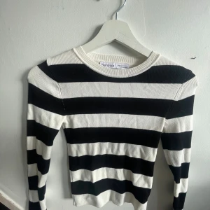 Svartvit randig ribbad tröja  - Säljer en svartvit långärmad tröja med breda horisontella ränder. Tröjan är ribbad och har en tight passform med rund halsringning. Perfekt för dig som gillar klassiska mönster och stilren design.