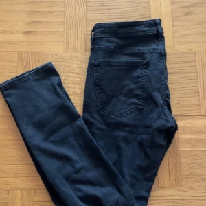 Svarta slim jeans SLIM/GLENN - Säljer ett par svarta slim fit jeans i modellen SLIM/GLENN. Jeansen har klassisk femficksdesign och raka ben. Perfekta för dig som gillar en smalare passform. Storlek W32 L34.