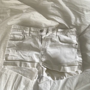 Vita jeansshorts - Säljer ett par vita jeansshorts med uppvikta ben. Perfekta för varma dagar och enkla att matcha med olika toppar.