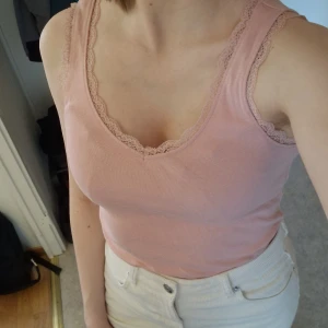 Rosa linnetopp med spets från Asos - Säljer en ljusrosa linnetopp från Asos med fina spetsdetaljer längs kanterna. I storlek S och bomull. Den har en djup v-ringning både fram och bak. Perfekt nu under våren och inför sommaren. Knappt använd. Skriv vid frågor!✨️ Samfraktar gärna så kika in mina andra inlägg!✨️