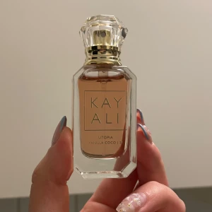 Kayali Vanilla Coco 21  - Kayali Utopia Vanilla Coco 21 är en lyxig parfym med tydliga inslag av vit blomma, vanilj och kokos. Doften har även pudriga, söta och träiga toner. Det är en mini parfym 10 ml. Har ej använt den.