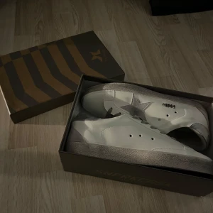 Vita sneakers med grå stjärndetalj från Golden Goose - Helt ny. 