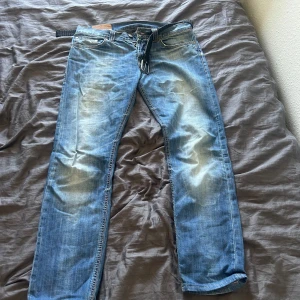 Dondup Lucky 33 - Säljer ett par klassiska blå Dondup jeans med snygga slitningar och kontrastsömmar. Passformen är rak och de har normal midja. Perfekta för en avslappnad stil. Finns ett litet hål bak vid fickan men går lätt att sy ihop själv men har inte orkat. 