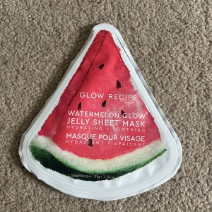 Watermelon Glow Jelly Sheet Mask - En ansiktsmask i form av en jelly sheet mask med vattenmelonmotiv från Glow Recipe. Masken är återfuktande och lugnande, perfekt för att ge huden extra glow och fukt. Kommer i en triangelformad förpackning som ser ut som en vattenmelon.