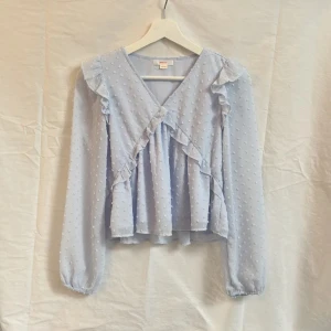 Volang blus - Säljer en supersnygg volangig blus från Gina Tricot som jag köpte för cirka ett år sedan men har inte använt mer än 2 ggr. Har inga defekter och är i väldigt bra skick!