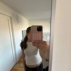 Vit tight t-shirt - Säljer en enkel och stilren vit t-shirt med tight passform. T-shirten har korta ärmar och rund halsringning. Perfekt att matcha med jeans eller kjol för en clean look. I storlek xs. Den har en liten smink fläck som inte går bort i tvätten 
