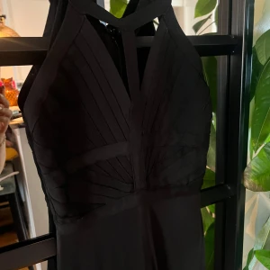 Svart bodyconklänning från Herve Leger - Säljer en svart bodyconklänning från Herve Leger i storlek S. Klänningen har en tight passform, markerade sömmar och breda axelband med snygga cut-outs framtill. Perfekt för dig som vill ha en stilren och elegant look.