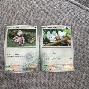 Pokémonkort: Slakoth och Tandemaus - Två Pokémonkort säljes: Slakoth med 70 HP och Tandemaus med 30 HP. Båda korten har klassisk Pokémon-design med färgglada illustrationer och engelska texter. Perfekt för samlare eller Pokémon-fans som vill utöka sin kortsamling.