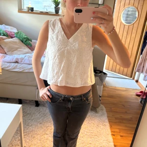 Vit broderad croppad linnetopp - Säljer en vit croppad linnetopp med broderade blommor och v-ringning🤍