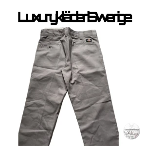 Dickies  kostymbyxor  - Säljer ett par beige kostymbyxor från Dickies i modellen Slim Straight. Byxorna har klassisk passform med raka ben, dragkedja och knapp i midjan. Perfekta för en clean och stilren look.Jag skickar måtten till dig i ett privat meddelande. defekten i fotot n4